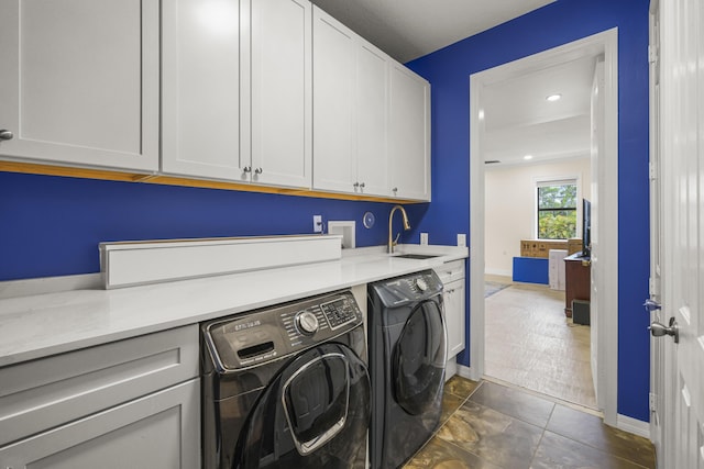 laundry room with separate washer and dryer, sink, and cabinets