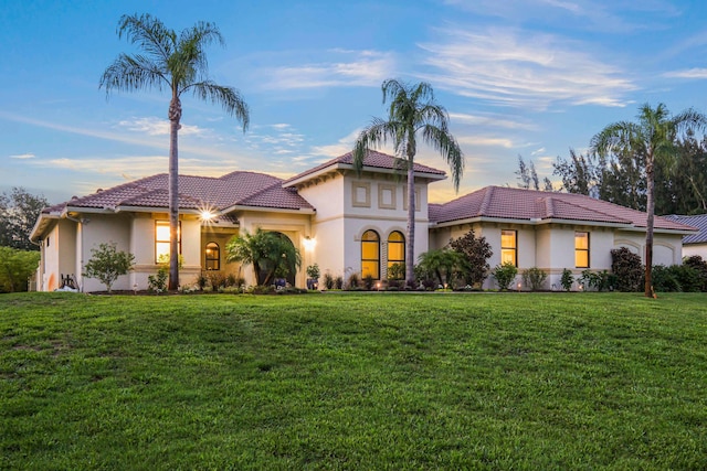 mediterranean / spanish home featuring a yard