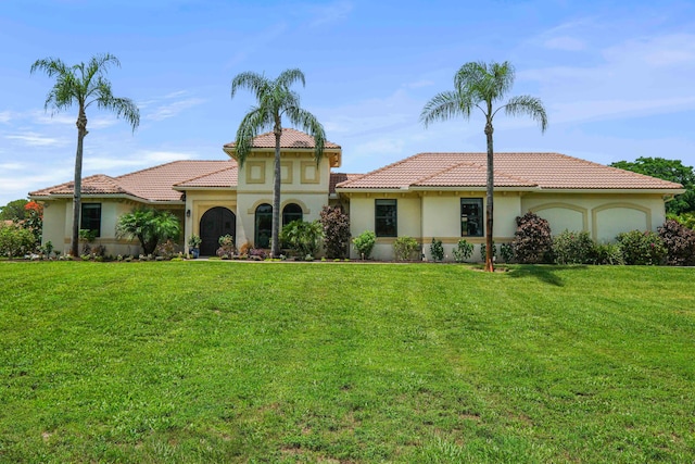 mediterranean / spanish-style house with a front lawn