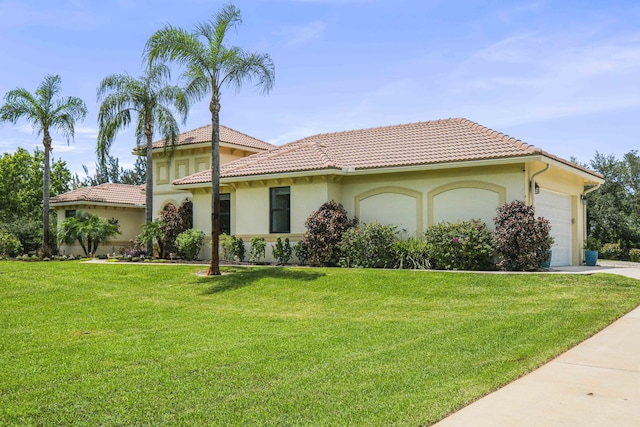 mediterranean / spanish house featuring a garage and a front lawn