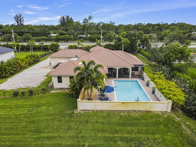 view of pool featuring a lawn, a sunroom, and a patio