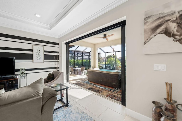 living room featuring ceiling fan, light tile patterned flooring, crown molding, and a tray ceiling