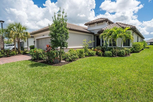 mediterranean / spanish house with a garage and a front lawn