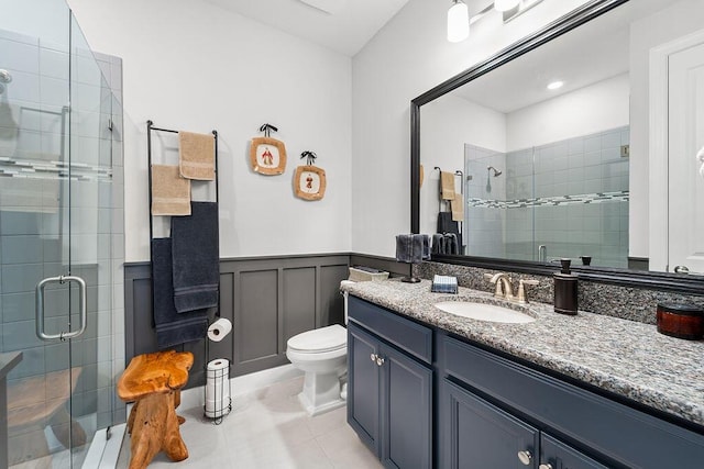 bathroom with toilet, vanity, tile patterned floors, and walk in shower