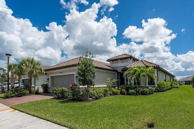 mediterranean / spanish-style house featuring a front yard and a garage