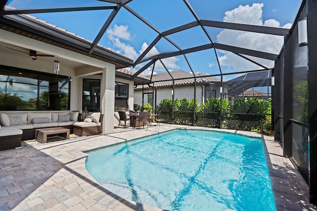 view of pool featuring glass enclosure, ceiling fan, a patio, and an outdoor hangout area