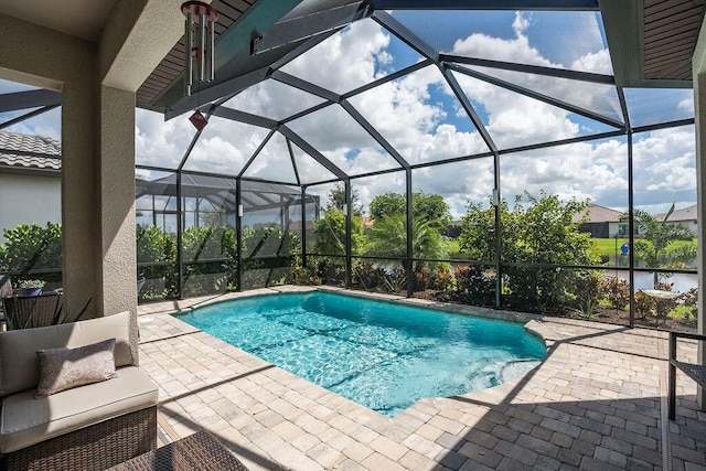 view of swimming pool featuring a lanai and a patio