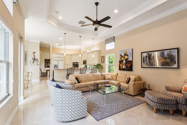 living room with light tile patterned floors, a raised ceiling, ceiling fan, and ornamental molding