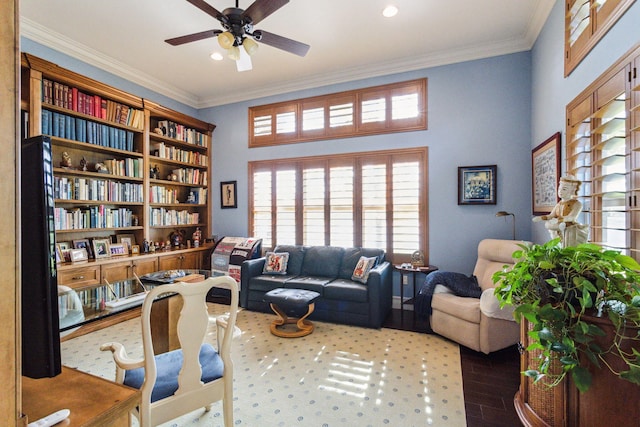 living area with ceiling fan and ornamental molding