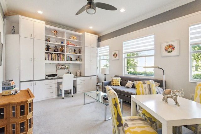 interior space featuring ceiling fan, crown molding, and light colored carpet