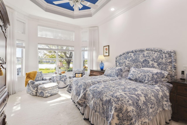 bedroom with light carpet, a towering ceiling, ornamental molding, a tray ceiling, and ceiling fan