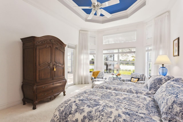 bedroom with multiple windows, light carpet, a raised ceiling, and ceiling fan