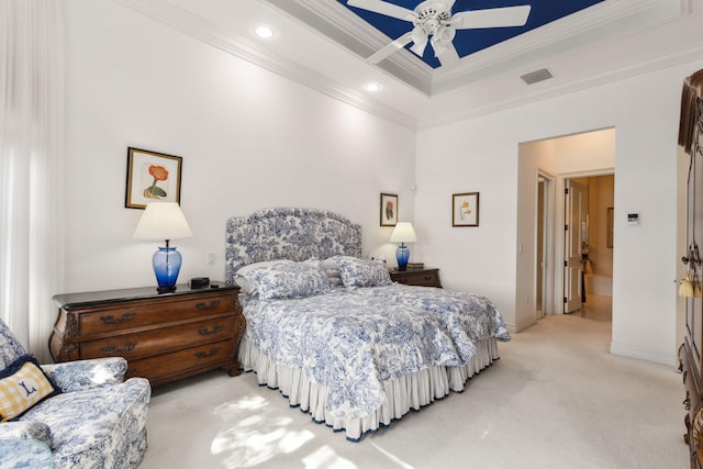 bedroom featuring light carpet, a raised ceiling, crown molding, ceiling fan, and connected bathroom