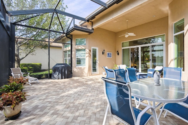 view of patio / terrace featuring glass enclosure, ceiling fan, and a grill