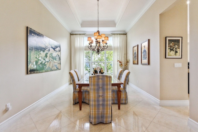 dining space with an inviting chandelier, ornamental molding, light tile patterned floors, and a tray ceiling