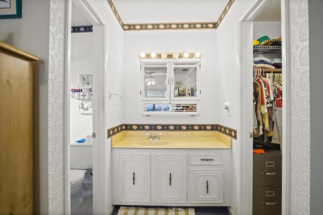 bathroom with vanity, a textured ceiling, and toilet