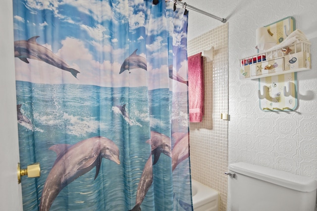 bathroom featuring shower / bathtub combination with curtain and toilet