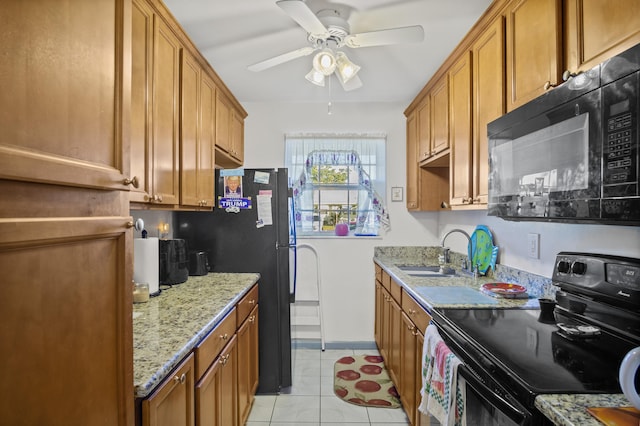 kitchen with light stone countertops, sink, ceiling fan, light tile patterned flooring, and black appliances