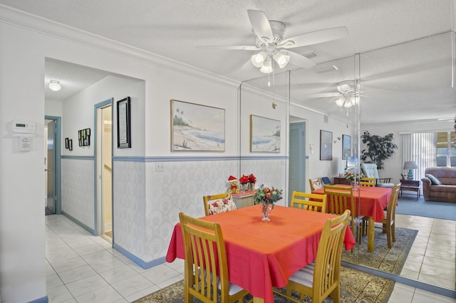 dining area featuring light tile patterned floors, a textured ceiling, ceiling fan, and crown molding