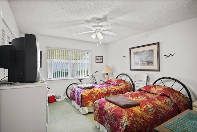 carpeted bedroom featuring ceiling fan and a textured ceiling