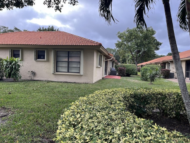 view of property exterior with a yard and central AC unit