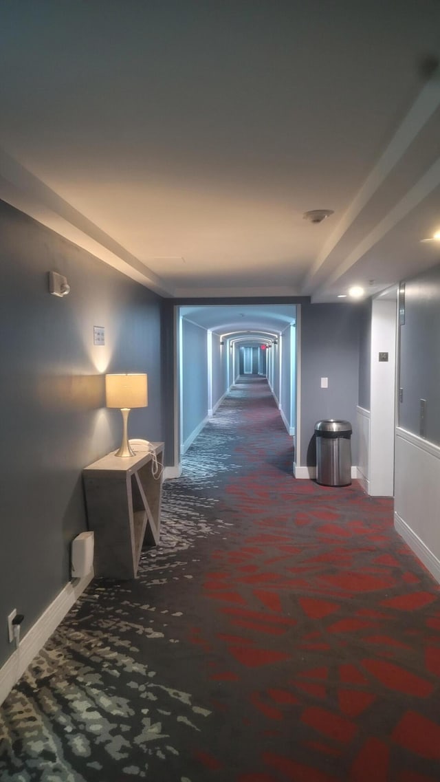 hallway featuring dark carpet