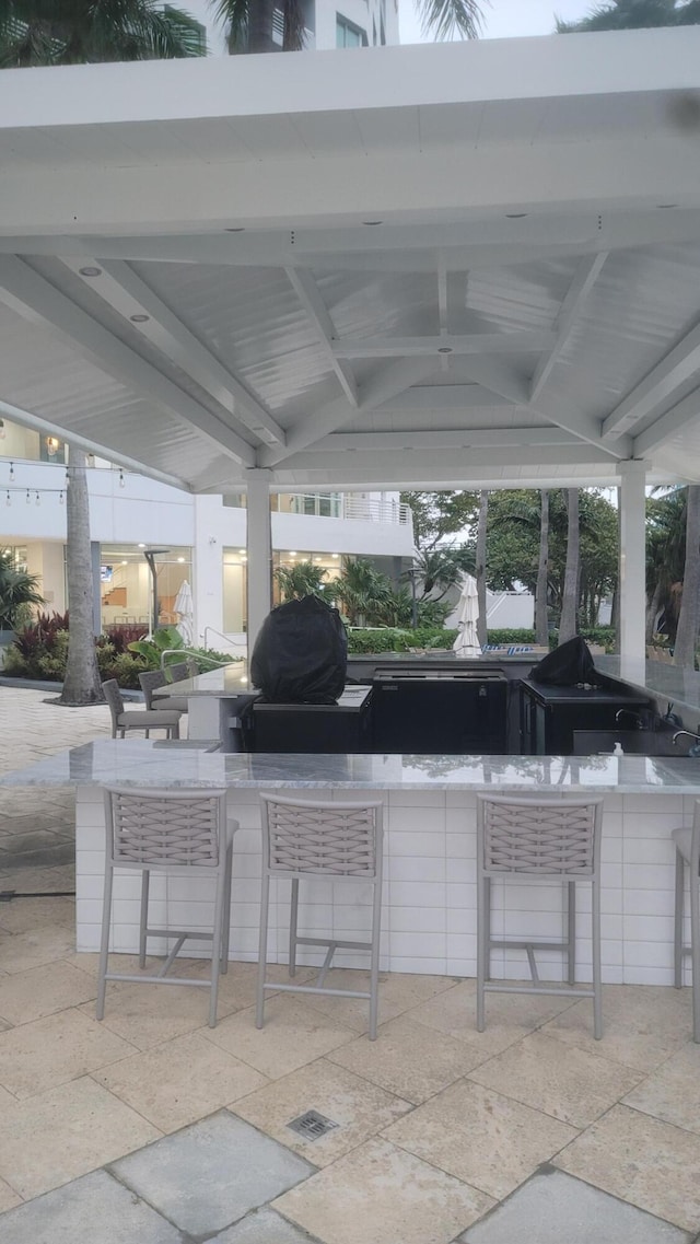 view of patio with a gazebo, ceiling fan, a grill, and exterior bar