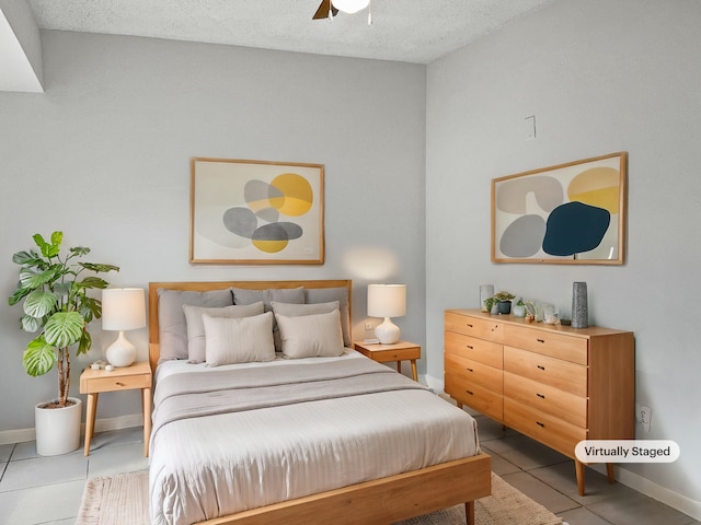 tiled bedroom featuring ceiling fan and a textured ceiling