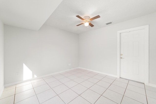 tiled spare room featuring ceiling fan and a textured ceiling