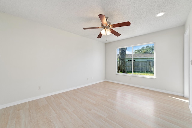 unfurnished room with ceiling fan, light hardwood / wood-style floors, and a textured ceiling