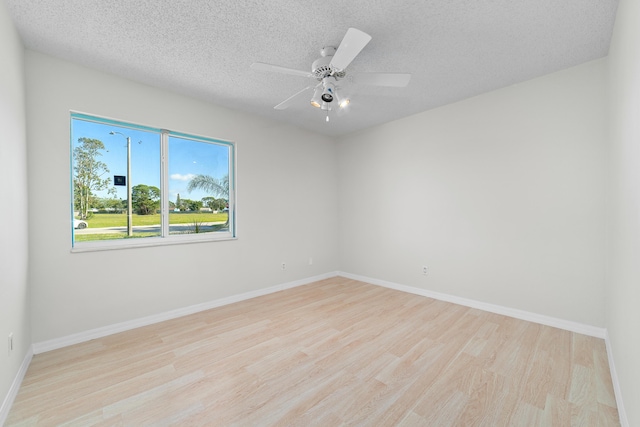 empty room featuring a textured ceiling, light hardwood / wood-style floors, and ceiling fan