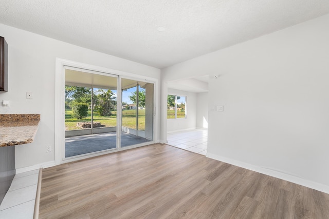 empty room featuring light hardwood / wood-style flooring and a textured ceiling