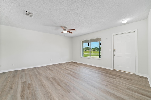 unfurnished room featuring light wood-type flooring, a textured ceiling, and ceiling fan