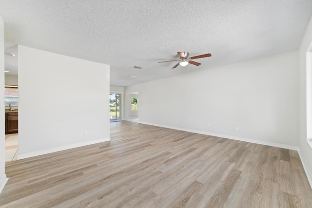 unfurnished living room with ceiling fan, light hardwood / wood-style floors, sink, and a textured ceiling