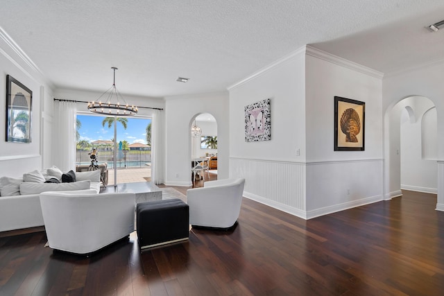 interior space with dark wood-type flooring, ornamental molding, a textured ceiling, and a notable chandelier