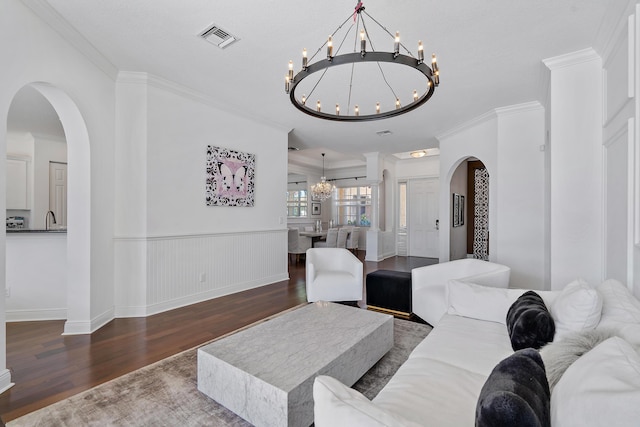 living room with ornamental molding, dark hardwood / wood-style floors, and a chandelier