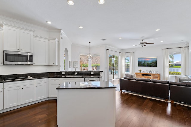 kitchen featuring appliances with stainless steel finishes, sink, white cabinets, and decorative light fixtures