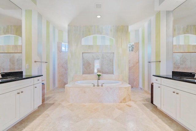 bathroom featuring vanity and tiled tub