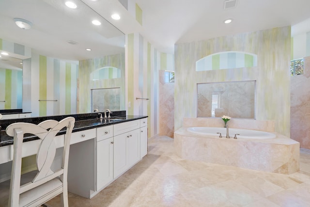 bathroom featuring vanity and a relaxing tiled tub