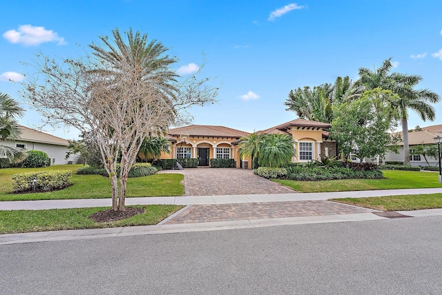 mediterranean / spanish home featuring a front yard