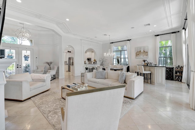 living room featuring an inviting chandelier, light tile patterned flooring, and ornamental molding