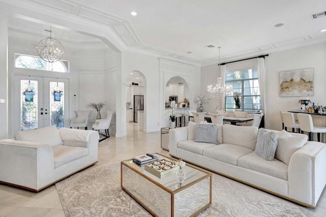 living room with french doors, a high ceiling, a chandelier, light tile patterned floors, and ornamental molding