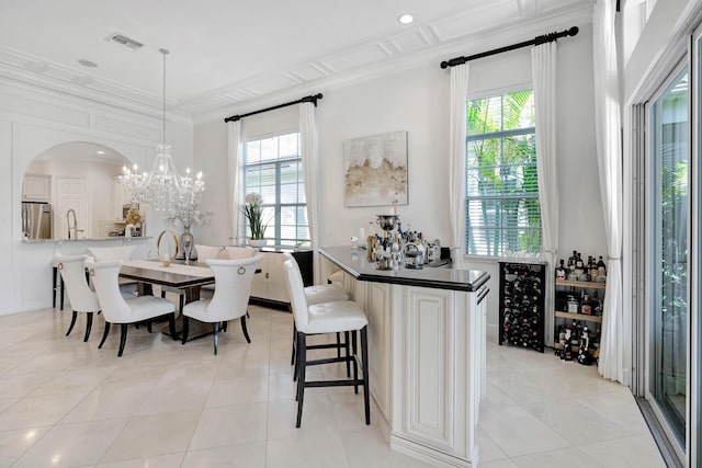 interior space featuring crown molding, light tile patterned floors, beverage cooler, and an inviting chandelier