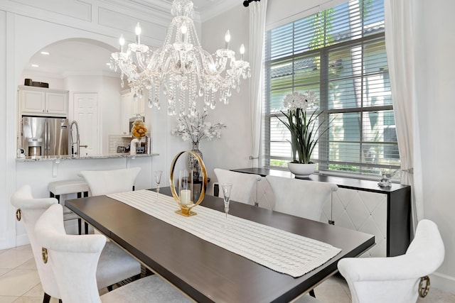 dining room featuring ornamental molding, sink, a notable chandelier, and light tile patterned flooring