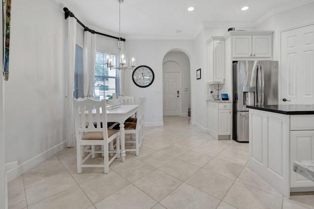 kitchen with stainless steel refrigerator with ice dispenser, light tile patterned floors, white cabinetry, and ornamental molding