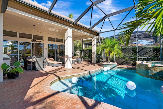 view of swimming pool featuring ceiling fan, glass enclosure, an in ground hot tub, and a patio