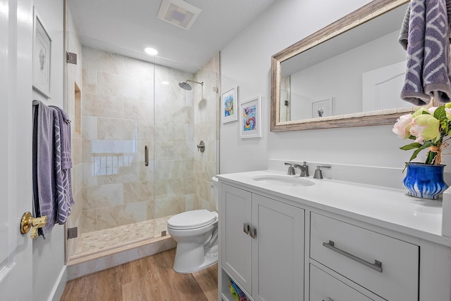 bathroom featuring toilet, hardwood / wood-style floors, vanity, and walk in shower