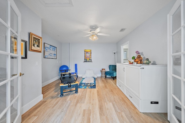 sitting room with light hardwood / wood-style floors and ceiling fan