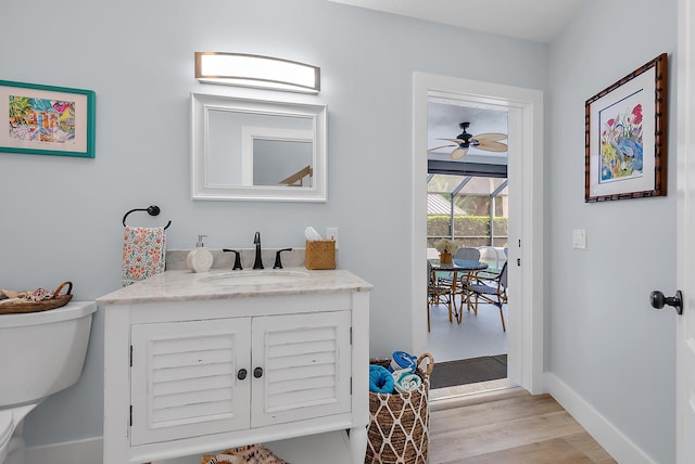 bathroom featuring wood-type flooring, vanity, toilet, and ceiling fan