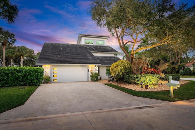 view of front facade featuring a garage and a yard